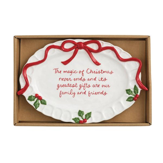 Decorative Christmas plate with red ribbon and holly design, featuring a quote, in a box.